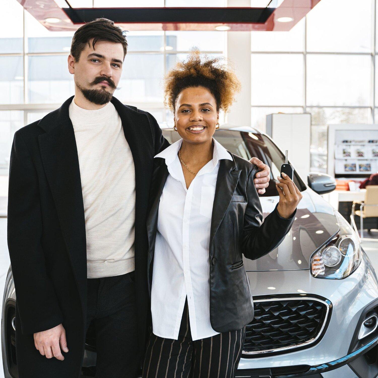 A couple test driving a car at a car dealership